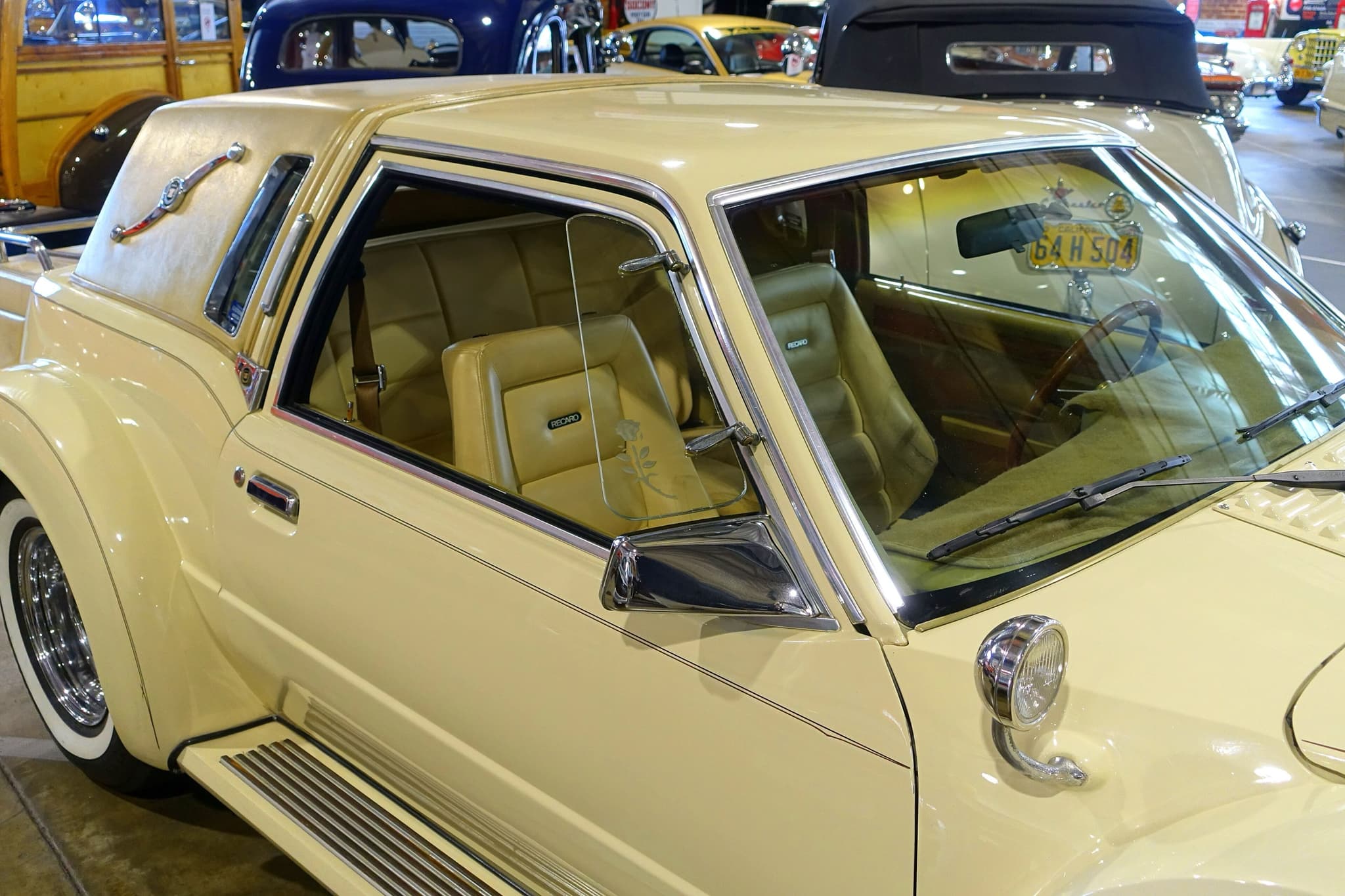 The side of a yellow Golden Spirit's cabin, with an etched-rose wind wing, a leather sports seat, a cowl lamp and a padded rear roof.