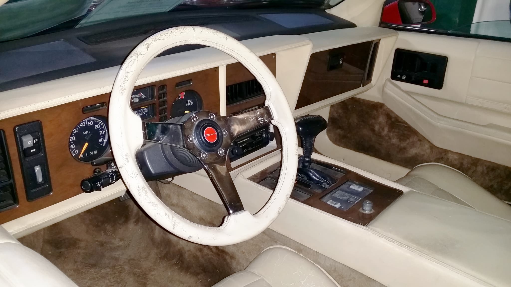 The cockpit of a QuickSilver with ivory leather seats, wood dash panels and an ivory leather-rimmed steering wheel. Opens a larger view