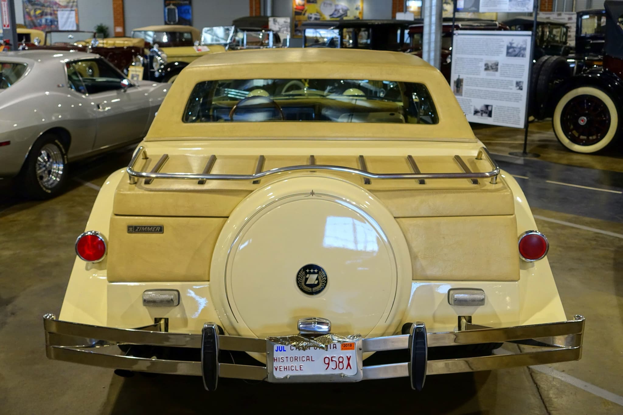 The rear of a yellow Golden Spirit with a luggage rack, a spare-wheel cover and chrome bumpers. Opens a larger view