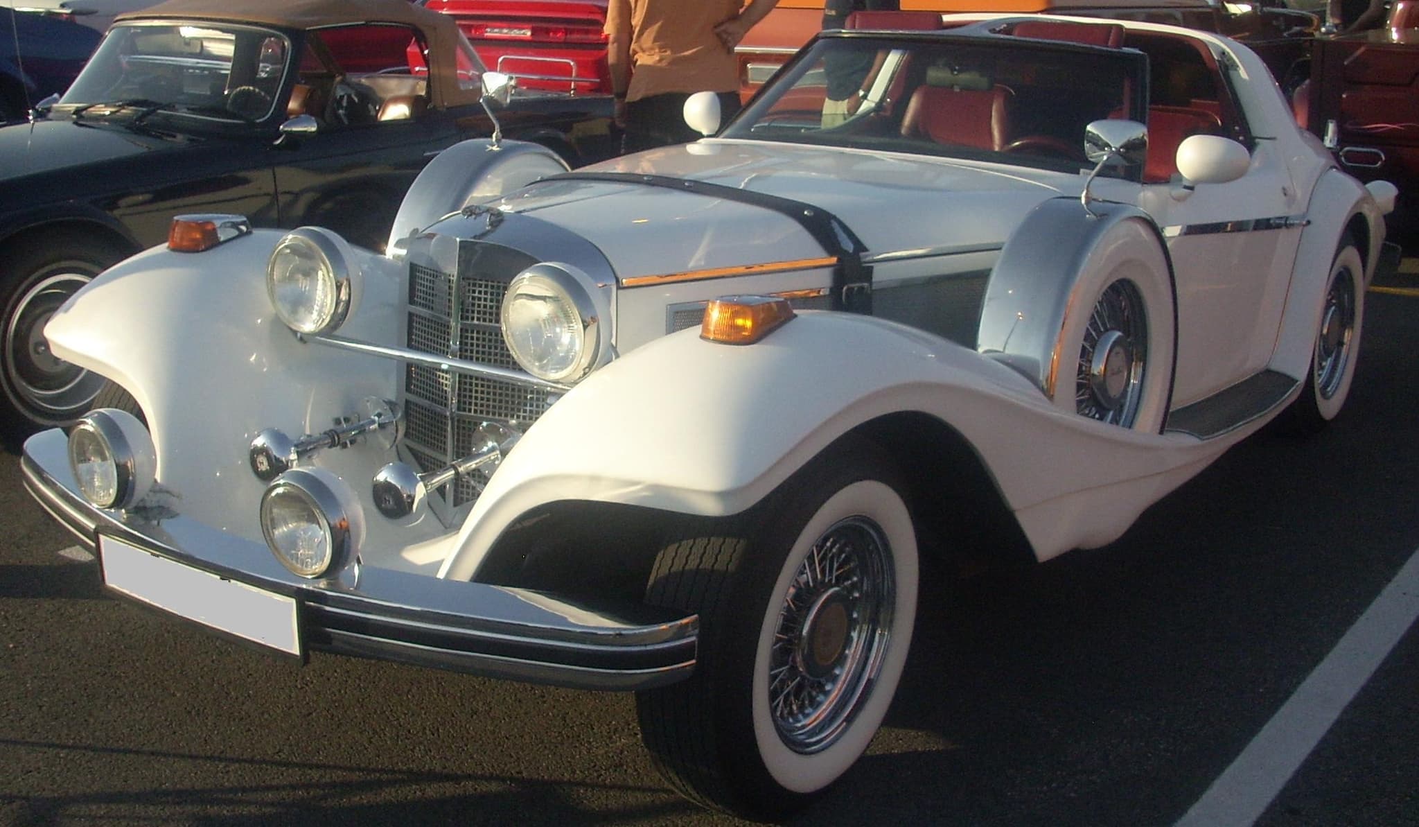 A white Phillips Berlina coupé with a tall chrome grille and separate headlamps in a car park.