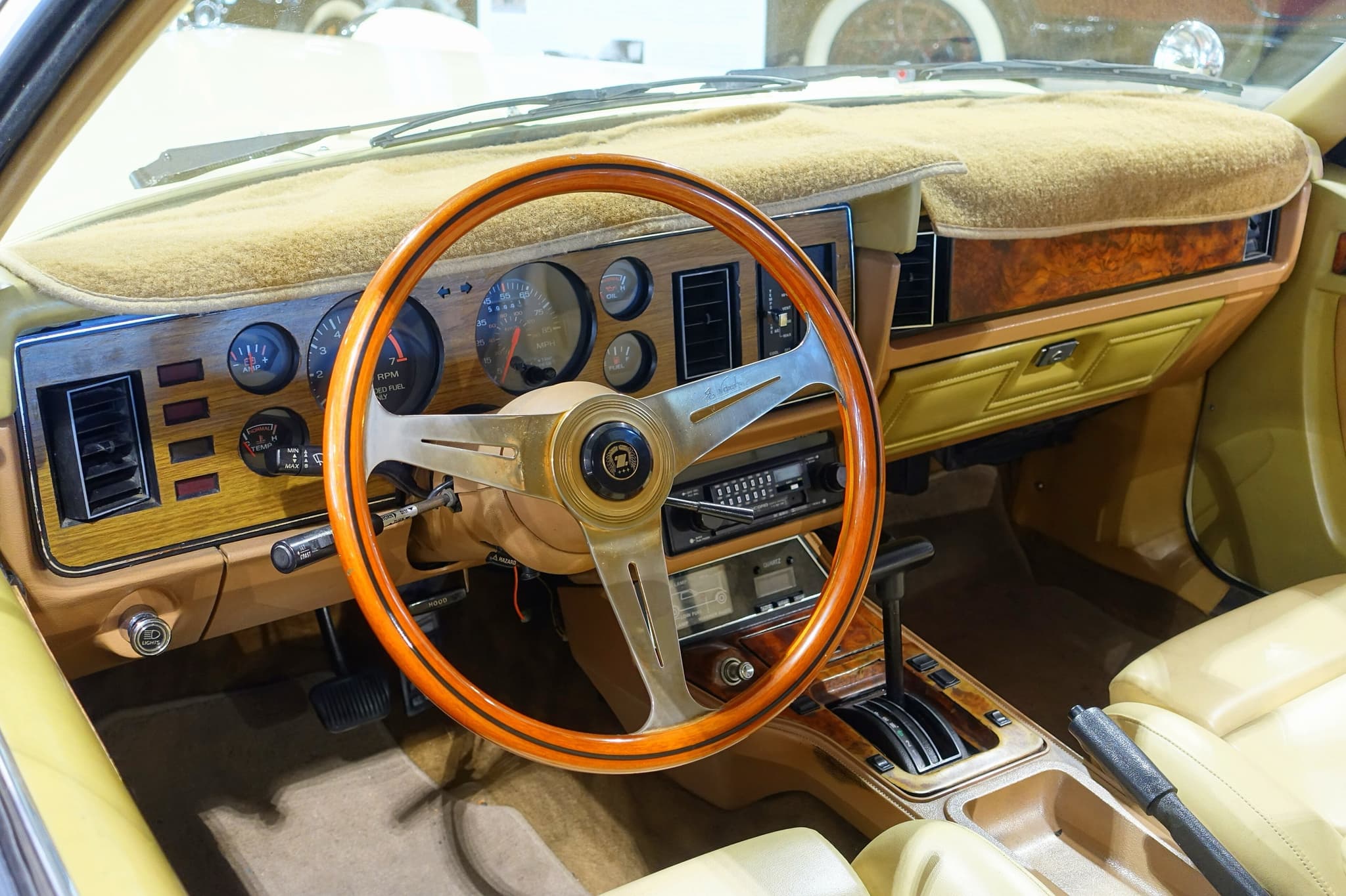 A Golden Spirit dashboard with a wood-rim steering wheel, round gauges in a woodgrain panel and a burr-walnut console.