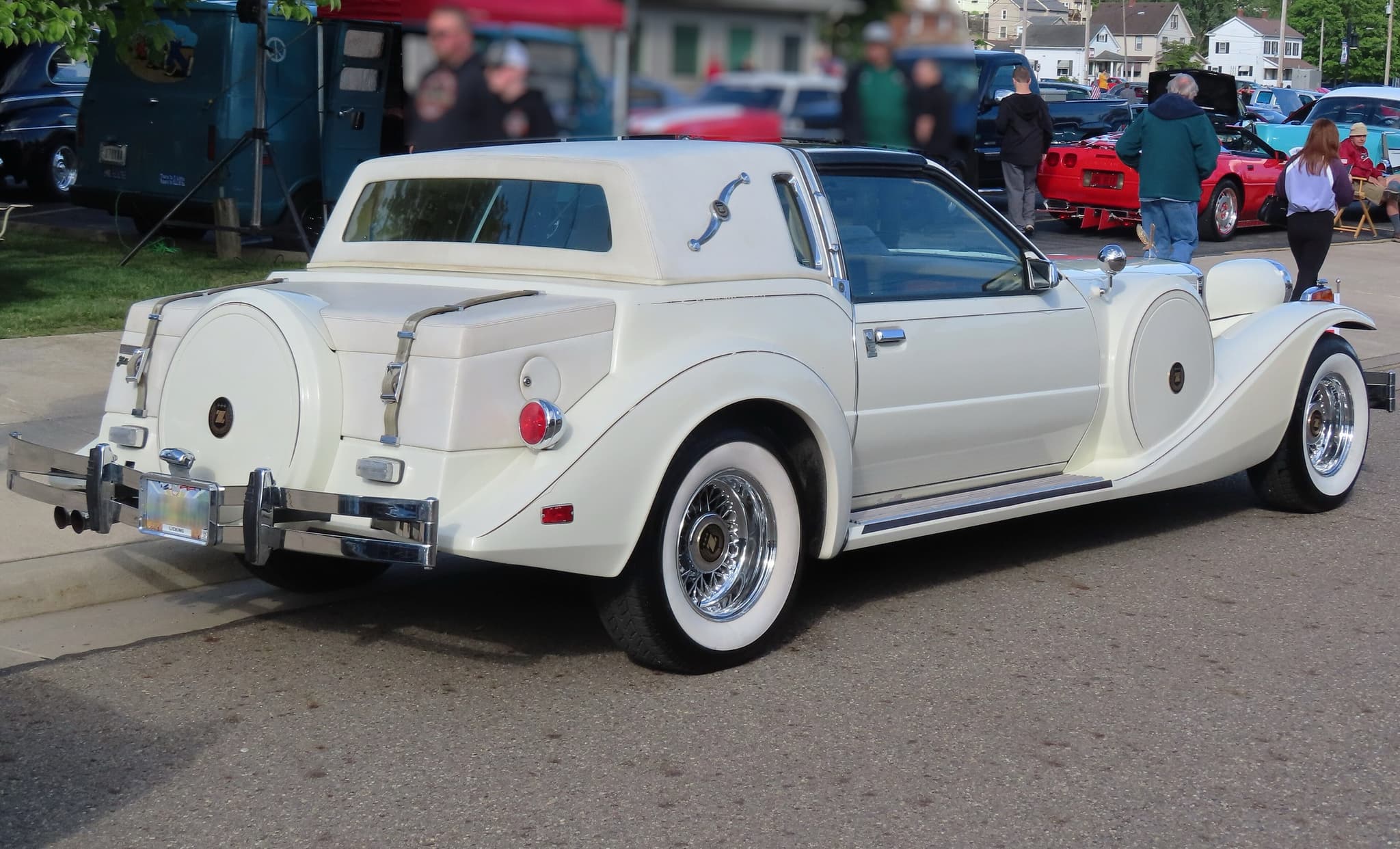 The rear three-quarter of a cream Golden Spirit coupé with a padded rear roof, a chrome landau bar and a spare-wheel cover.